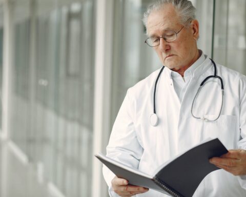contemplative doctor in uniform reading clinical records